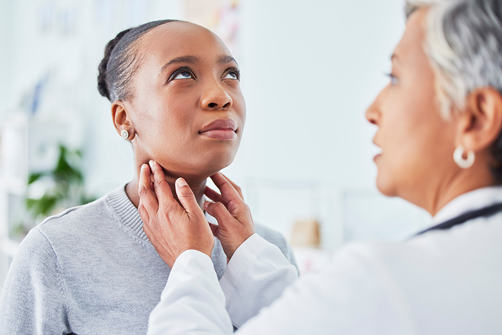 Doctor performs thyroid exam